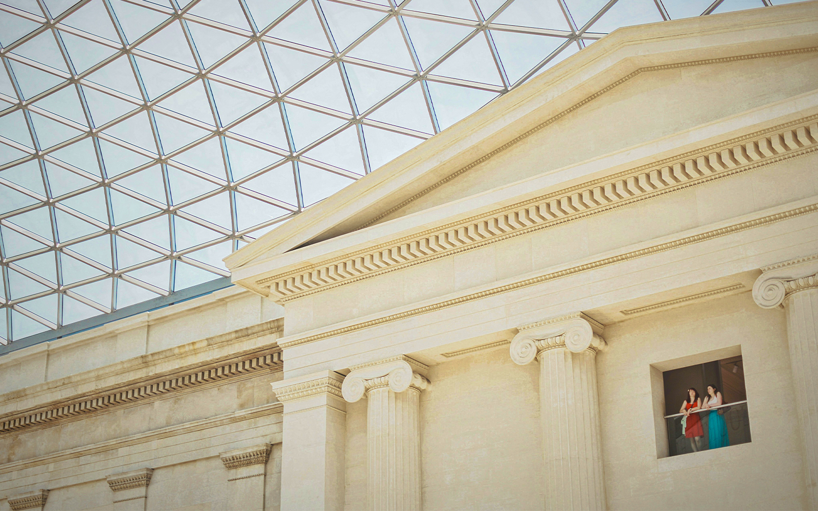British Museum interior with visitors on balcony under glass roof, London.