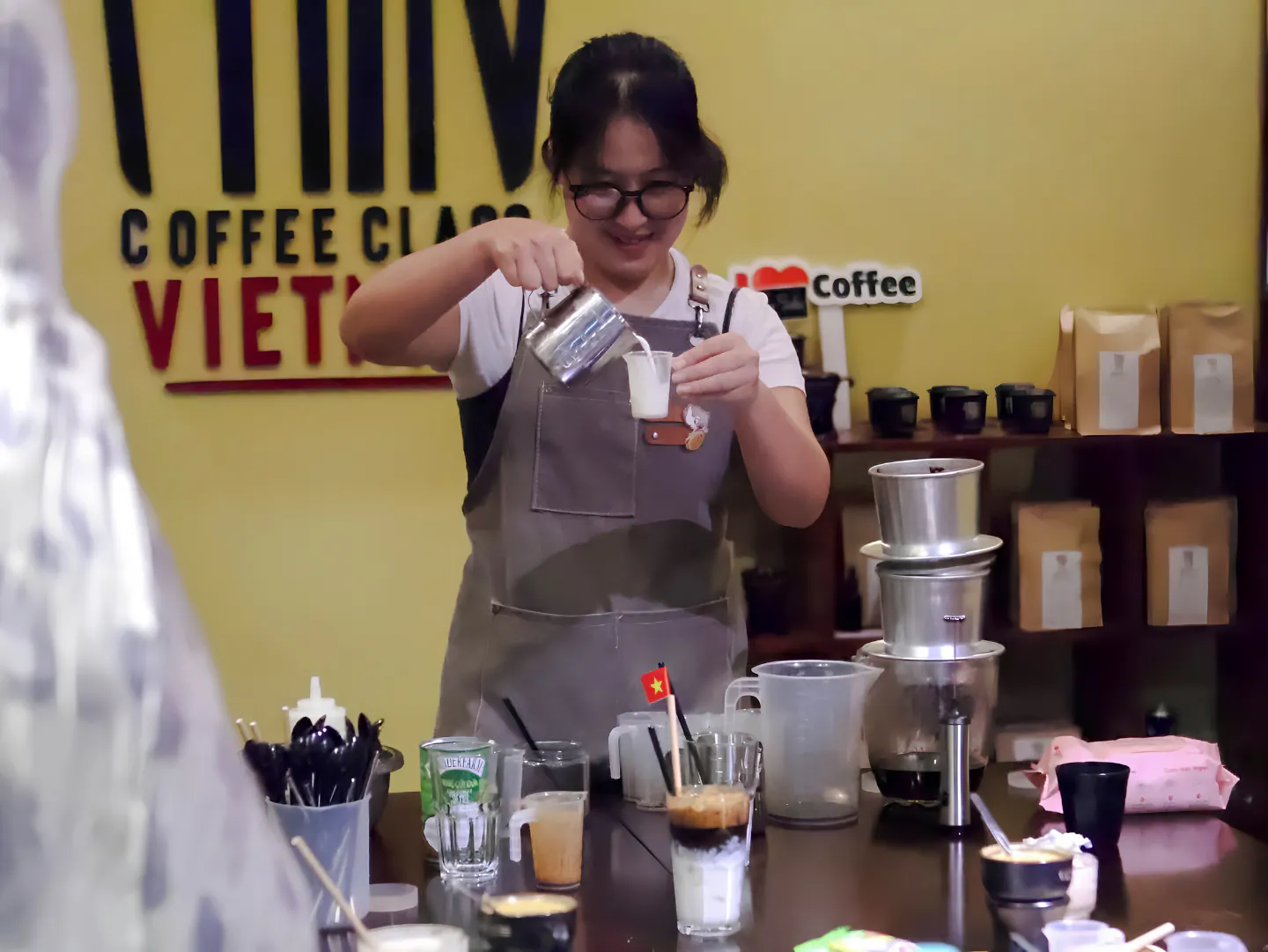 Barista pouring milk during a coffee-making class in Da Nang, Vietnam.