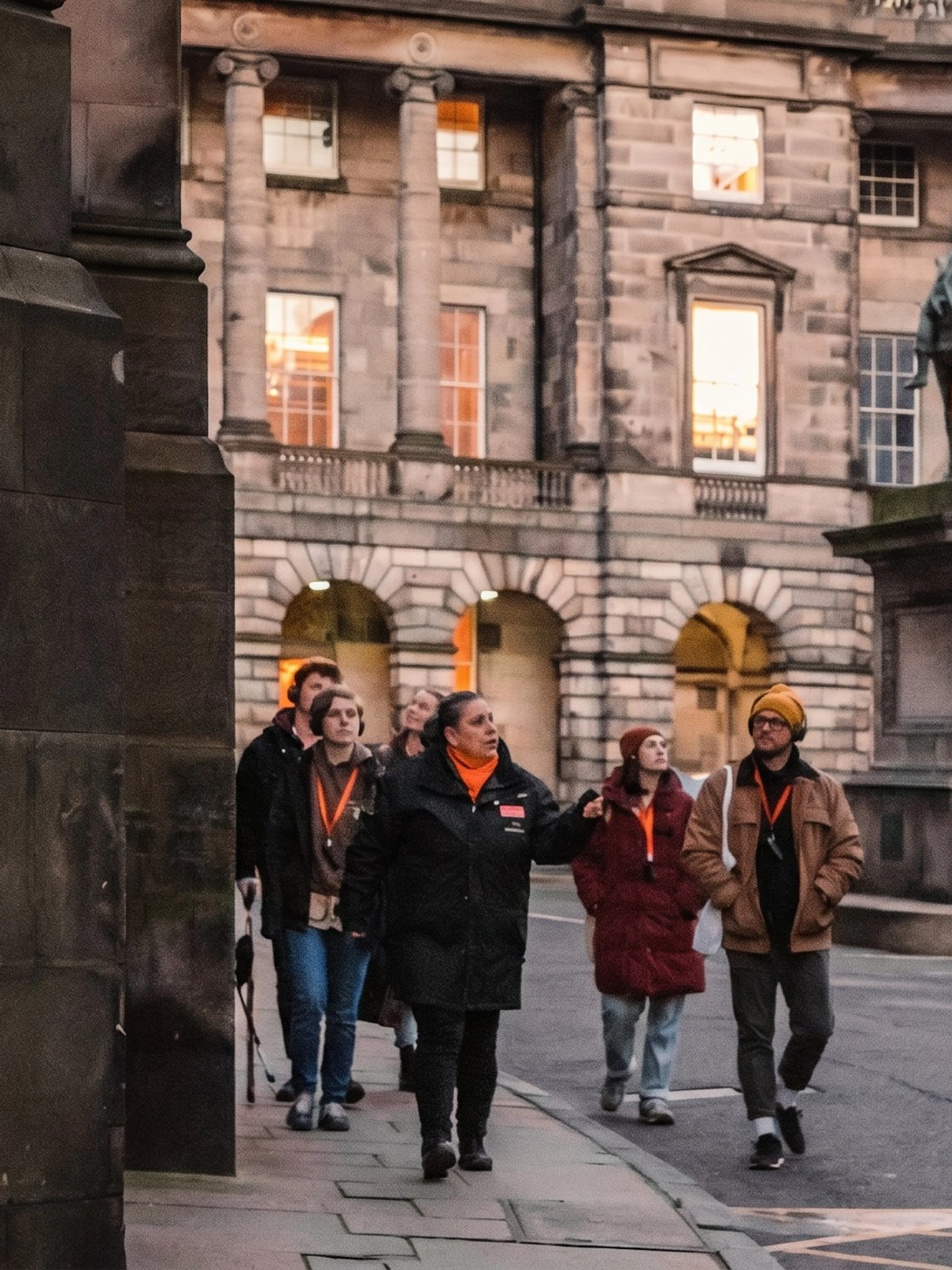 Tour group exploring historic Edinburgh courtyard with statue, part of Witches of Edinburgh tour.