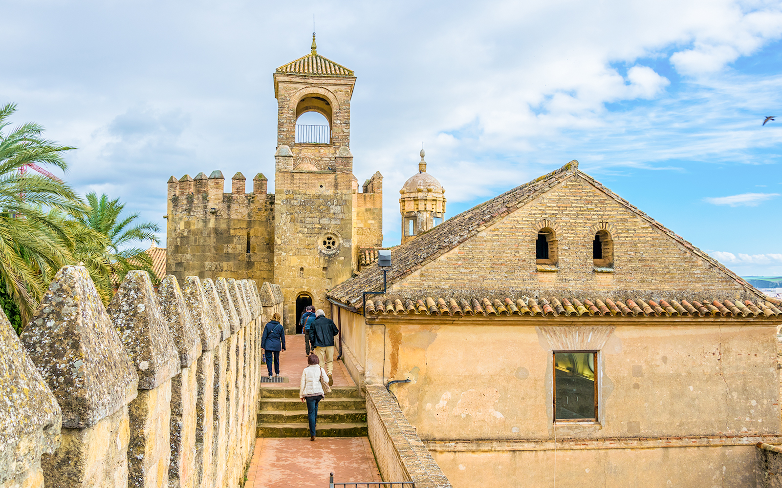 Visitors walking along the walls of Alcazar de los Reyes Cristianos, Cordoba.