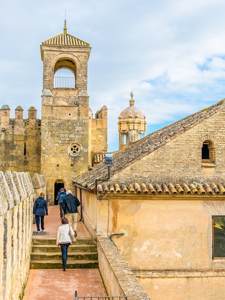 Visitors walking along the walls of Alcazar de los Reyes Cristianos, Cordoba.