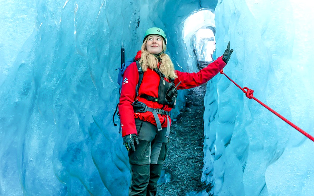 Hiker exploring Blue Ice Cave in Vatnajökull, Iceland.