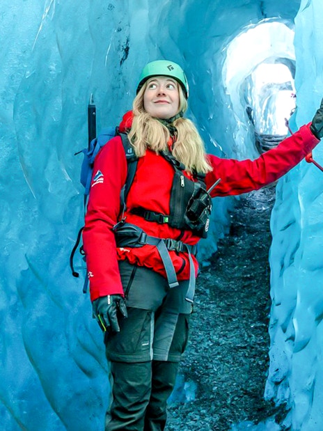 Hiker exploring Blue Ice Cave in Vatnajökull, Iceland.