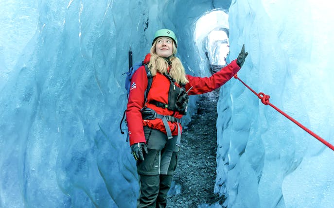 Hiker exploring Blue Ice Cave in Vatnajökull, Iceland.