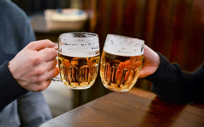 Beer glasses clinking during Prague beer tour.