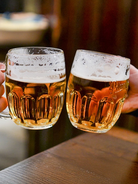 Beer glasses clinking during Prague beer tour.