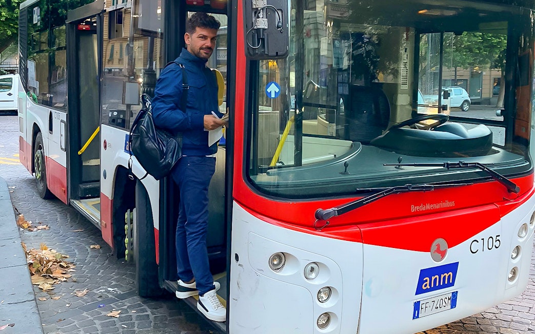 Man boarding a bus for airport transfer between Naples Capodichino Airport and Naples Maritime Station.