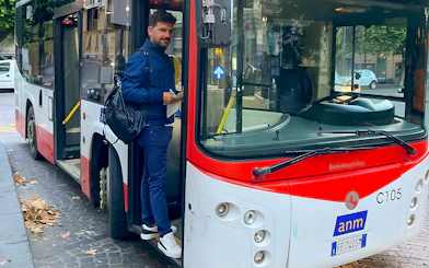 Man boarding a bus for airport transfer between Naples Capodichino Airport and Naples Maritime Station.