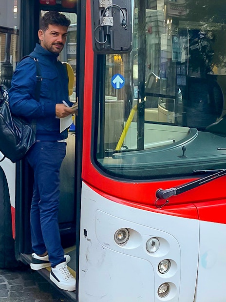 Man boarding a bus for airport transfer between Naples Capodichino Airport and Naples Maritime Station.