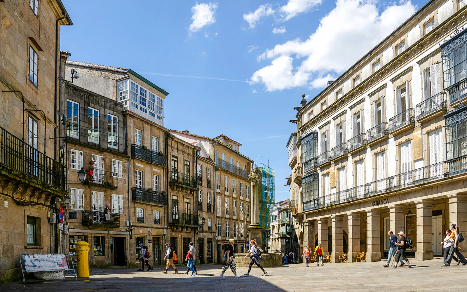 Praza De Cervantes in Santiago de Compostela with traditional buildings and people walking.