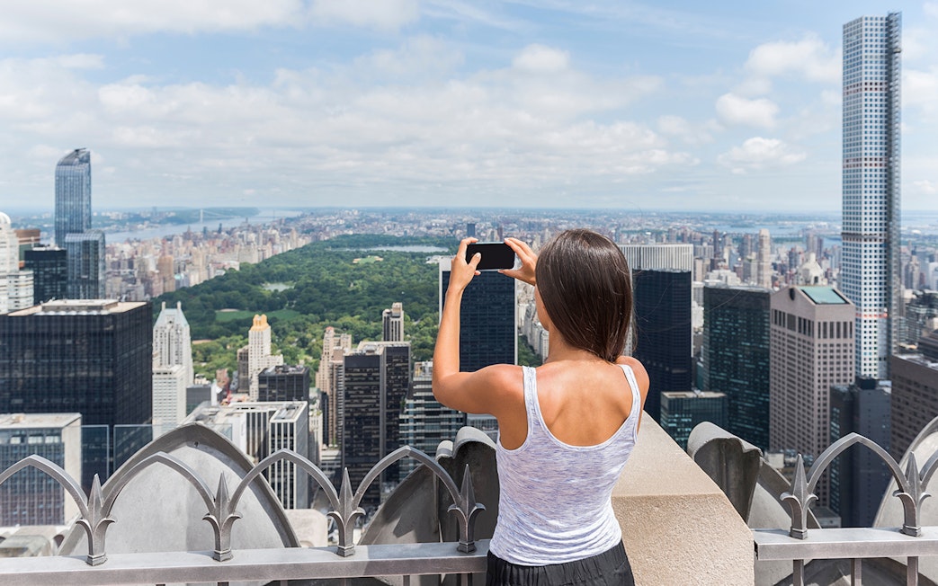 Visitors capturing New York City skyline from Top of the Rock Observation Deck.