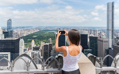 Visitors capturing New York City skyline from Top of the Rock Observation Deck.