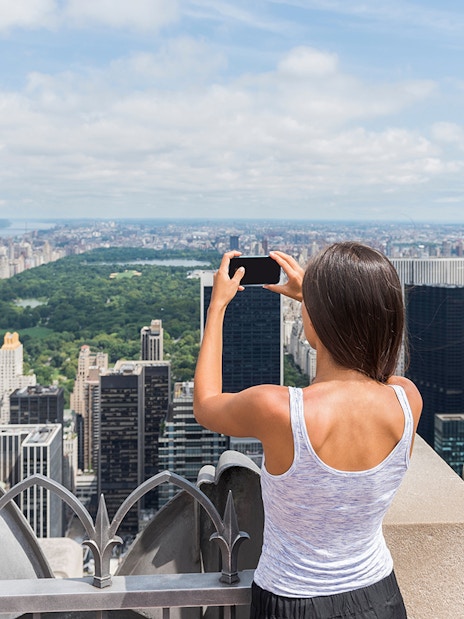 Visitors capturing New York City skyline from Top of the Rock Observation Deck.