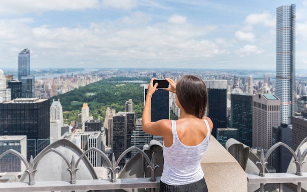 Visitors capturing New York City skyline from Top of the Rock Observation Deck.