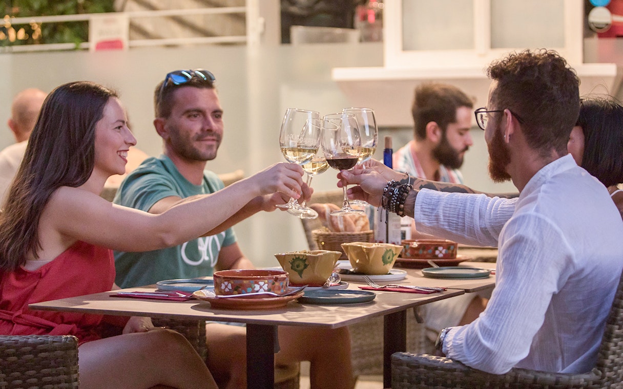 Group toasting with wine at Alegría Flamenco & Gastronomia dining experience.