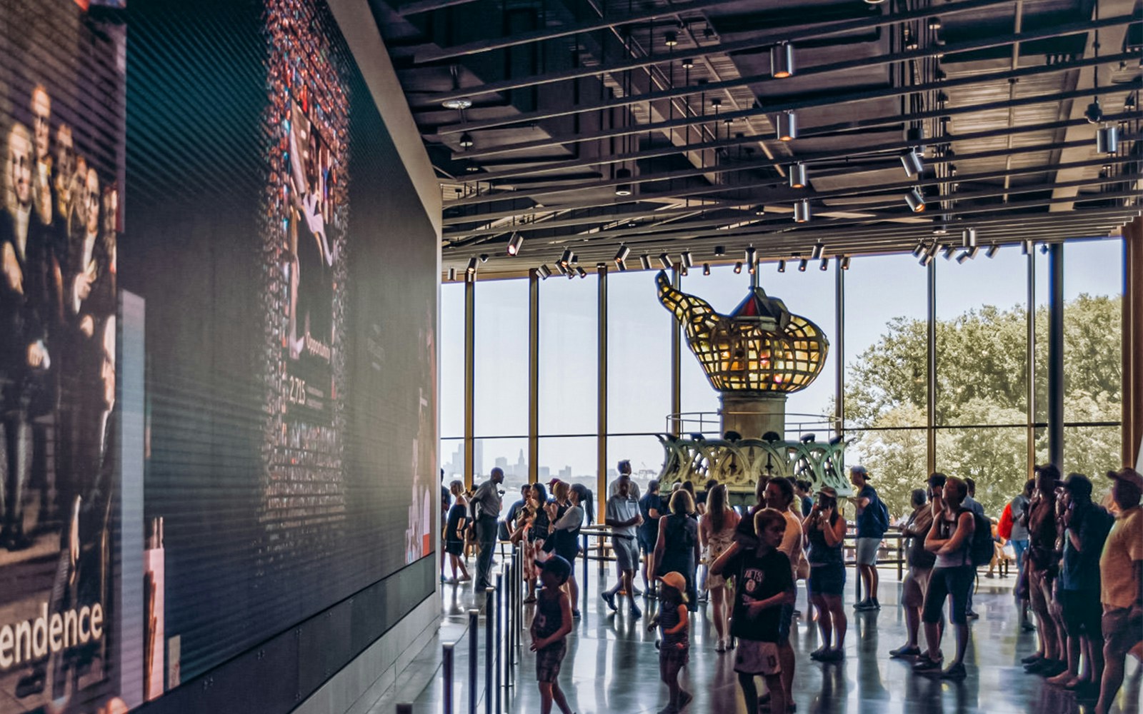 Visitors inside the Statue of Liberty Museum viewing the original torch exhibit.