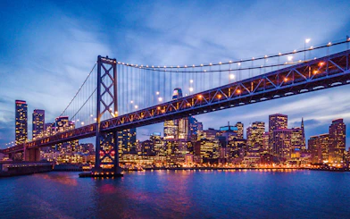 San Francisco skyline and Bay Bridge illuminated at night.
