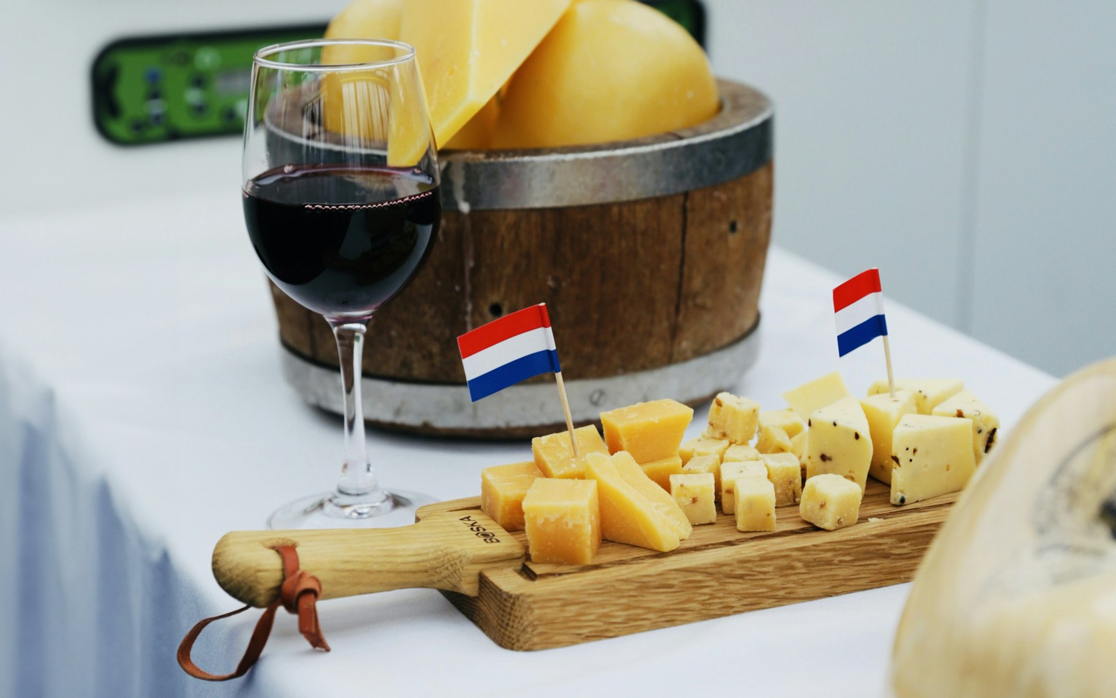 Cheese platter with Dutch flags and wine glass at Amsterdam Light Festival tasting.