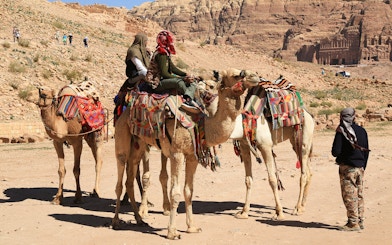 Camels with riders in colorful blankets at a desert site near Hurghada, Egypt.