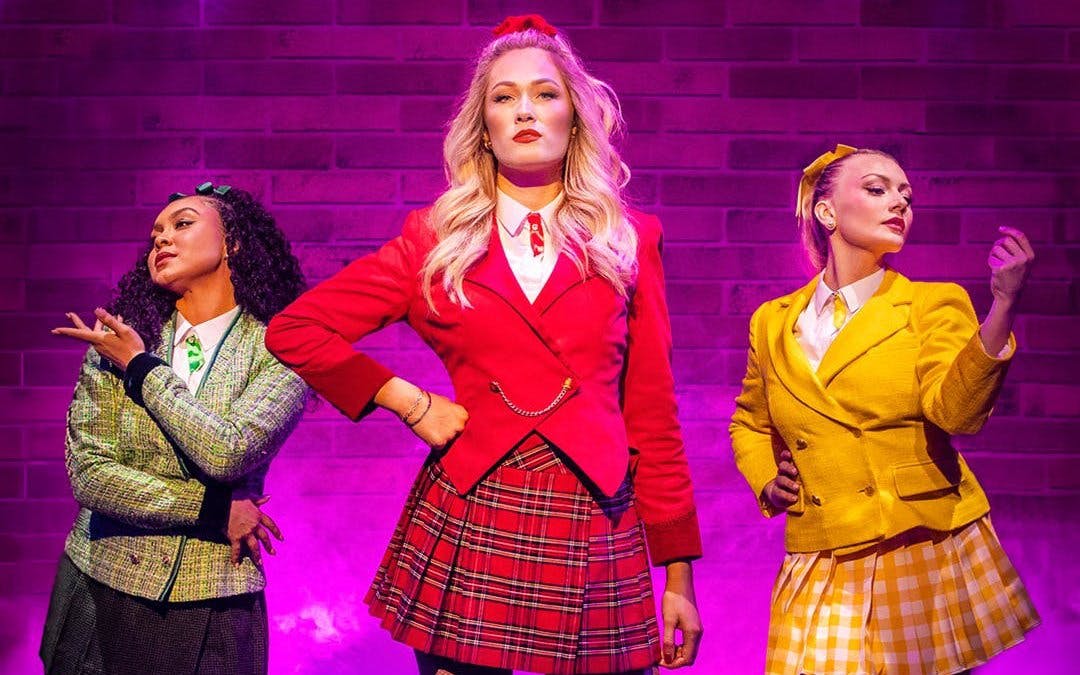 Performers in colorful costumes on stage in Heathers the Musical, West End.