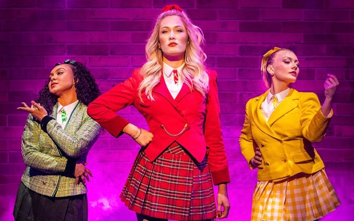 Performers in colorful costumes on stage in Heathers the Musical, West End.