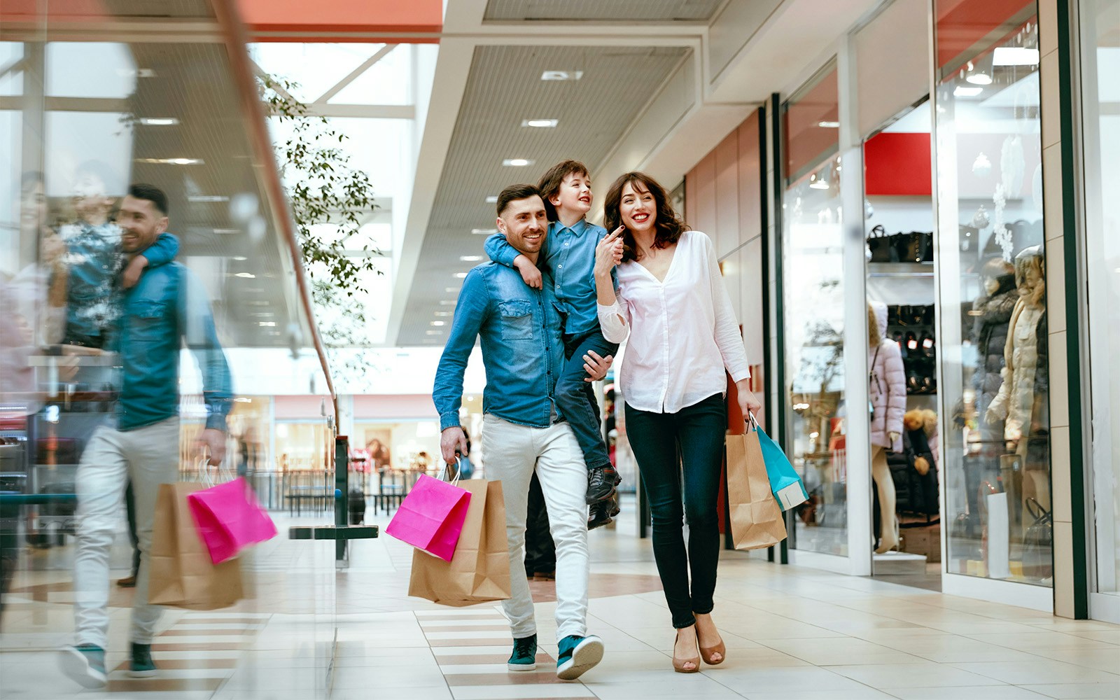 Family shopping in a Madrid mall, carrying colorful bags.