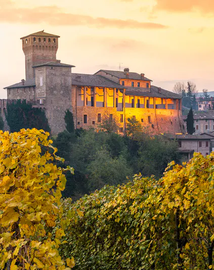 Castle in Modena, Italy, surrounded by vineyards at sunset near Museo Enzo Ferrari.