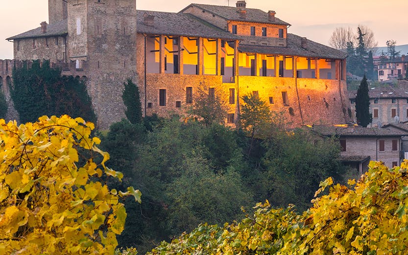 Castle in Modena, Italy, surrounded by vineyards at sunset near Museo Enzo Ferrari.