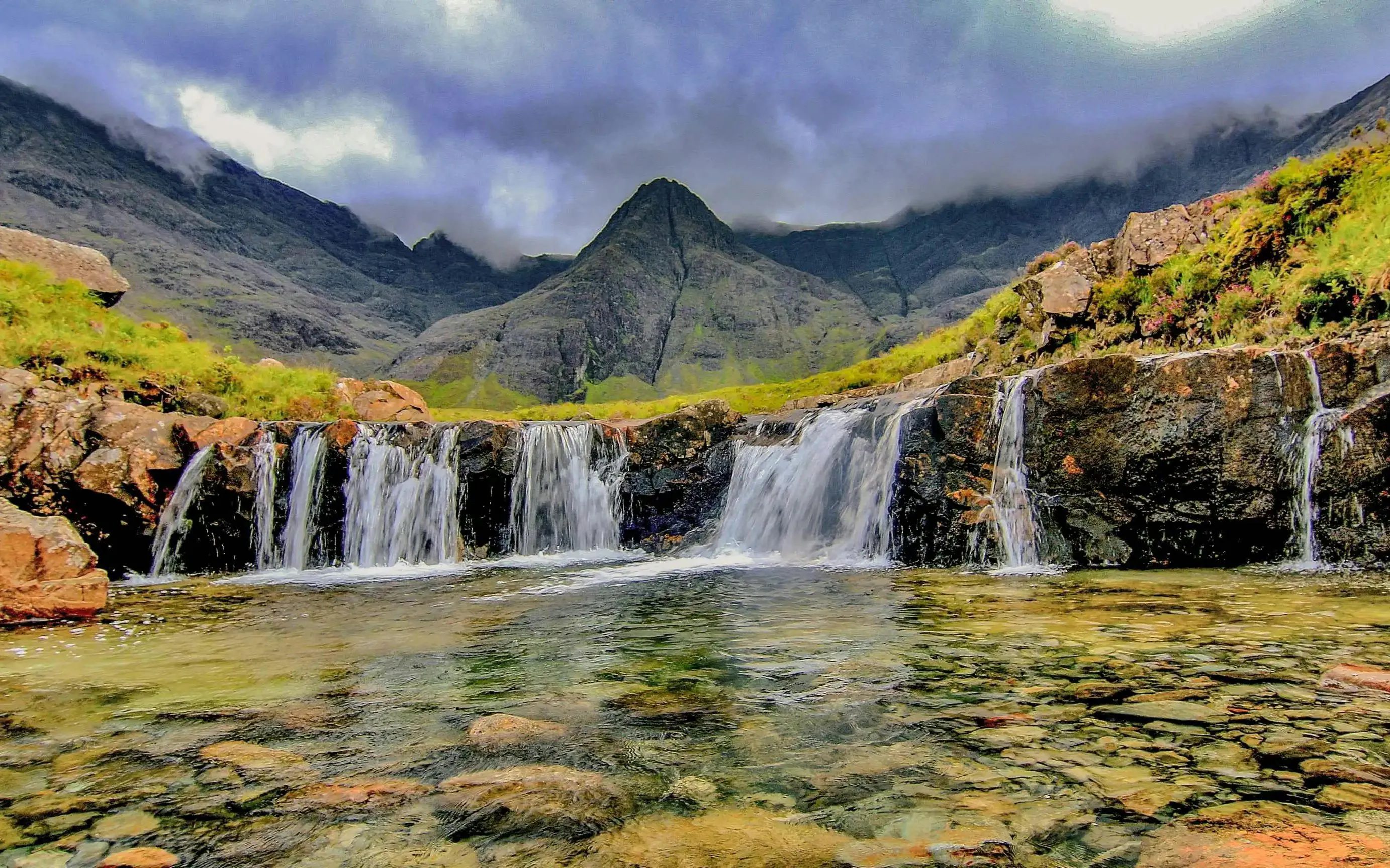 Waterfalls at Fairy Pools, Isle of Skye, with mountains in the background.