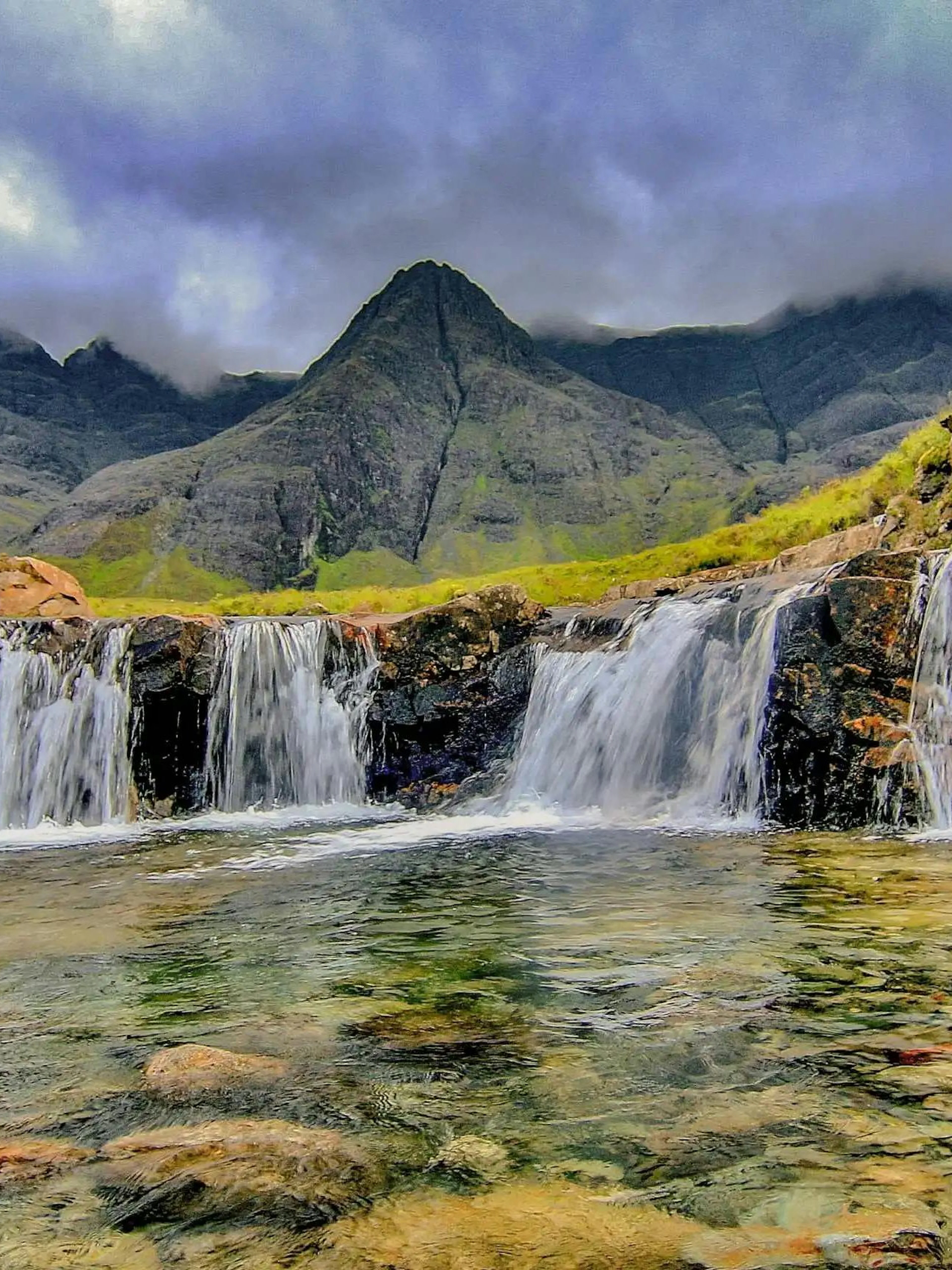 Waterfalls at Fairy Pools, Isle of Skye, with mountains in the background.