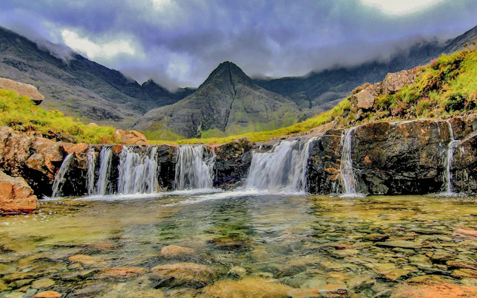 Waterfalls at Fairy Pools, Isle of Skye, with mountains in the background.