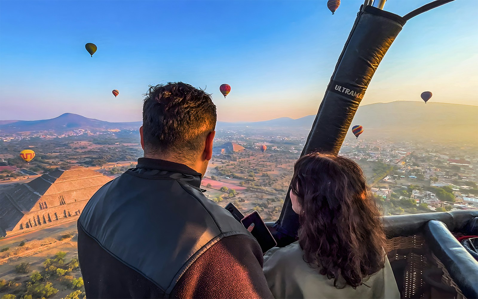 Hot air balloon passengers view Teotihuacan pyramid, Mexico.