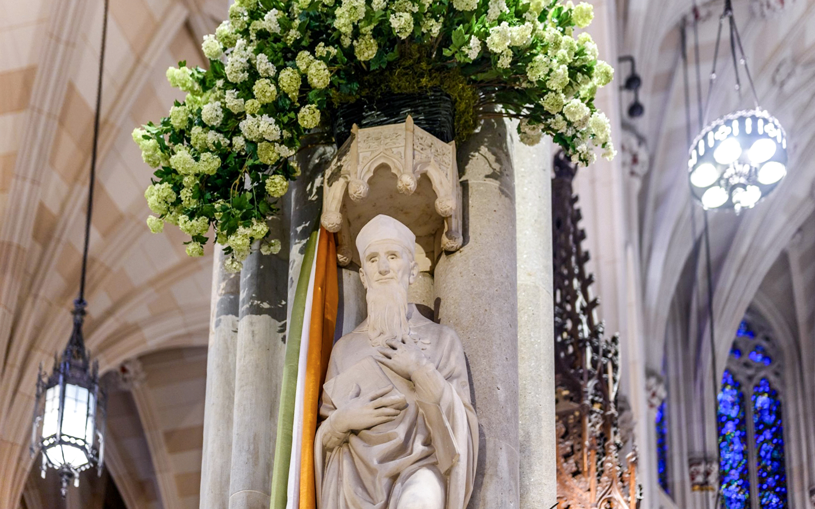 Statue inside St. Patrick's Cathedral with floral decoration, part of the official tour.