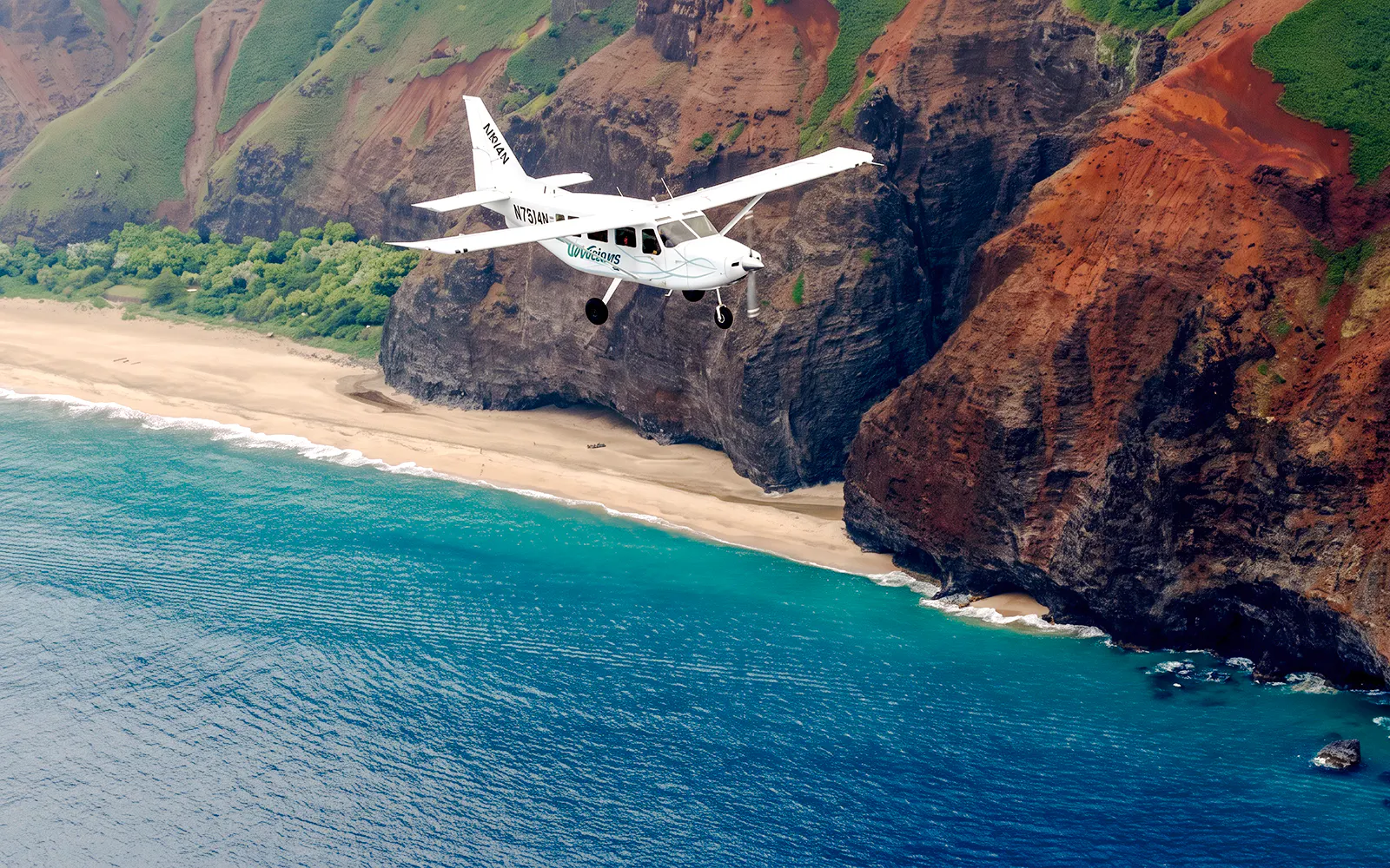 Small plane flying over Na Pali Coast, Kauai, showcasing cliffs and ocean during air tour.