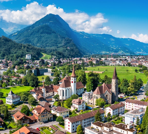 Aerial view of Interlaken, Switzerland, with churches and mountains in the background.