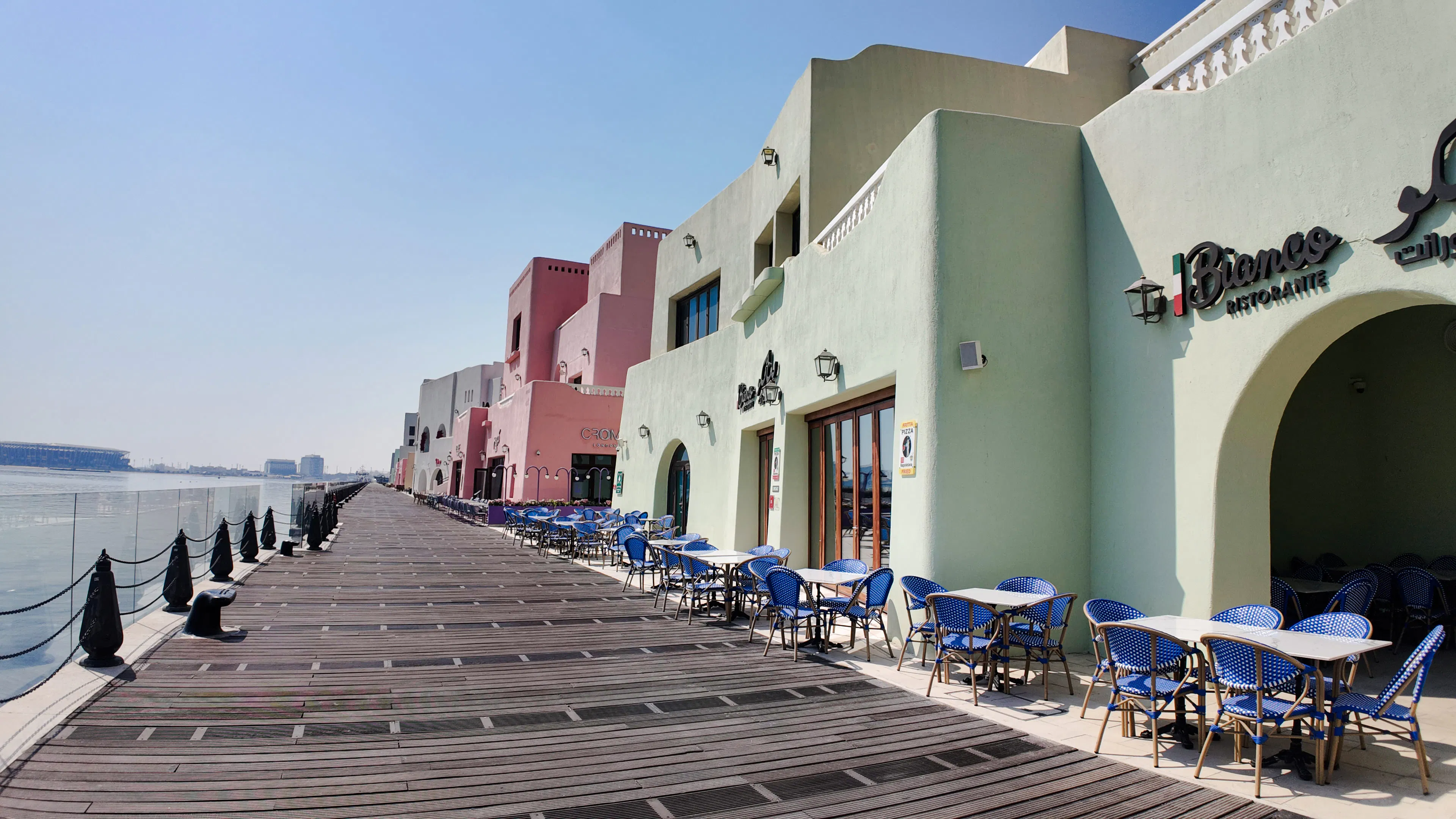 Colorful waterfront promenade with outdoor cafes in Doha, showcasing cultural architecture.