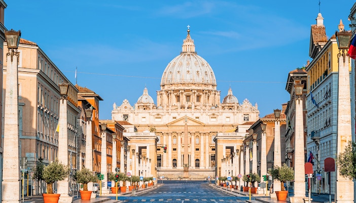 Vatican Grottoes with visitors exploring historic tombs beneath St. Peter's Basilica, Vatican City.