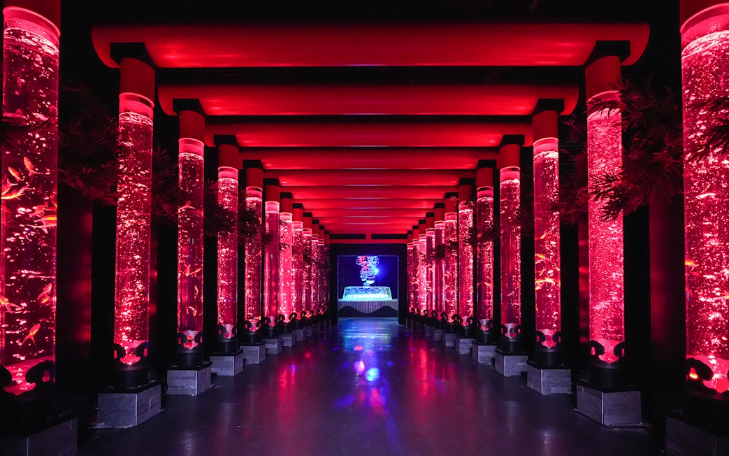 Illuminated red walkway with fish tanks at Art Aquarium Ginza.