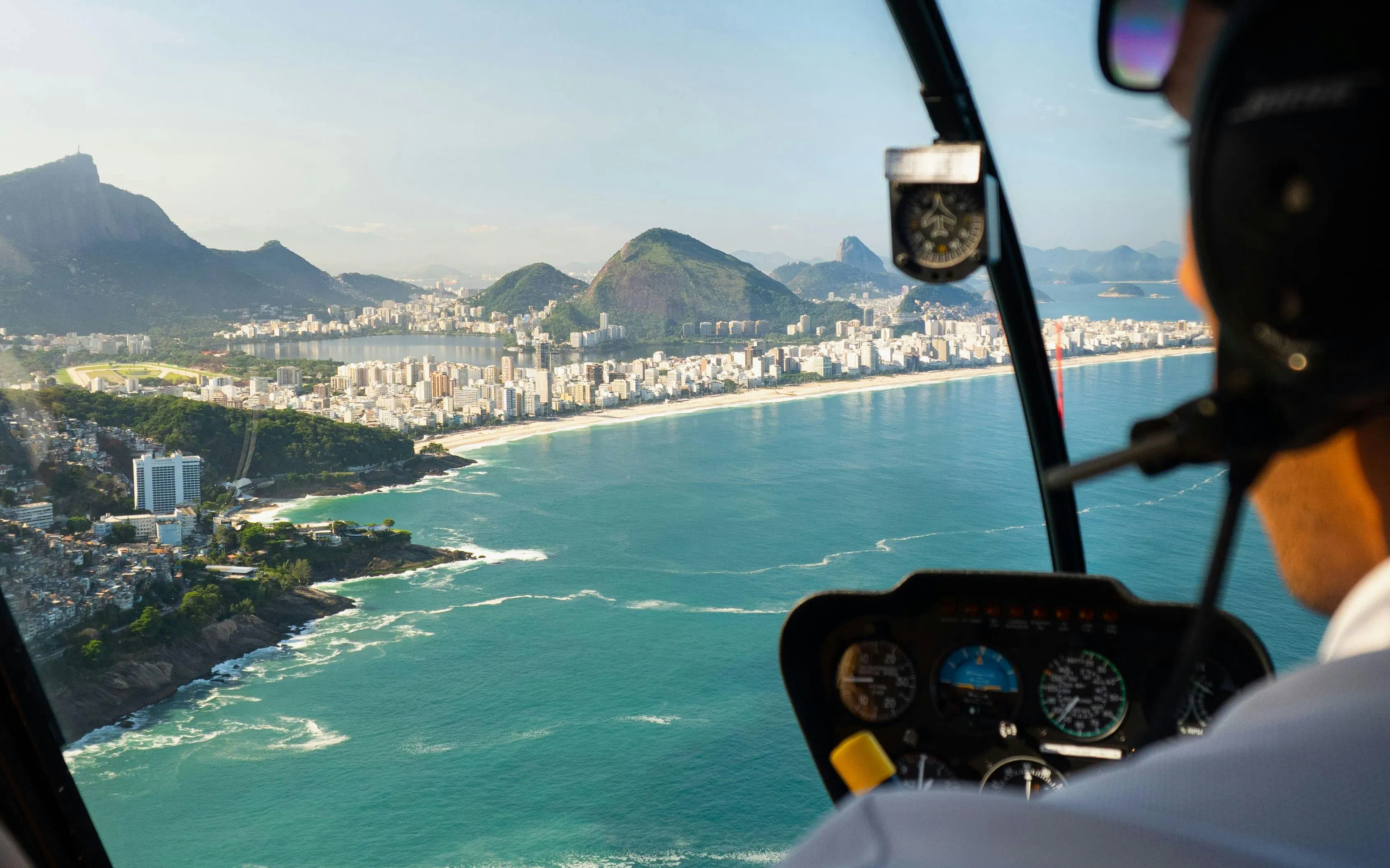 Aerial view from helicopter over Rio de Janeiro coastline, Brazil, with cityscape and ocean.