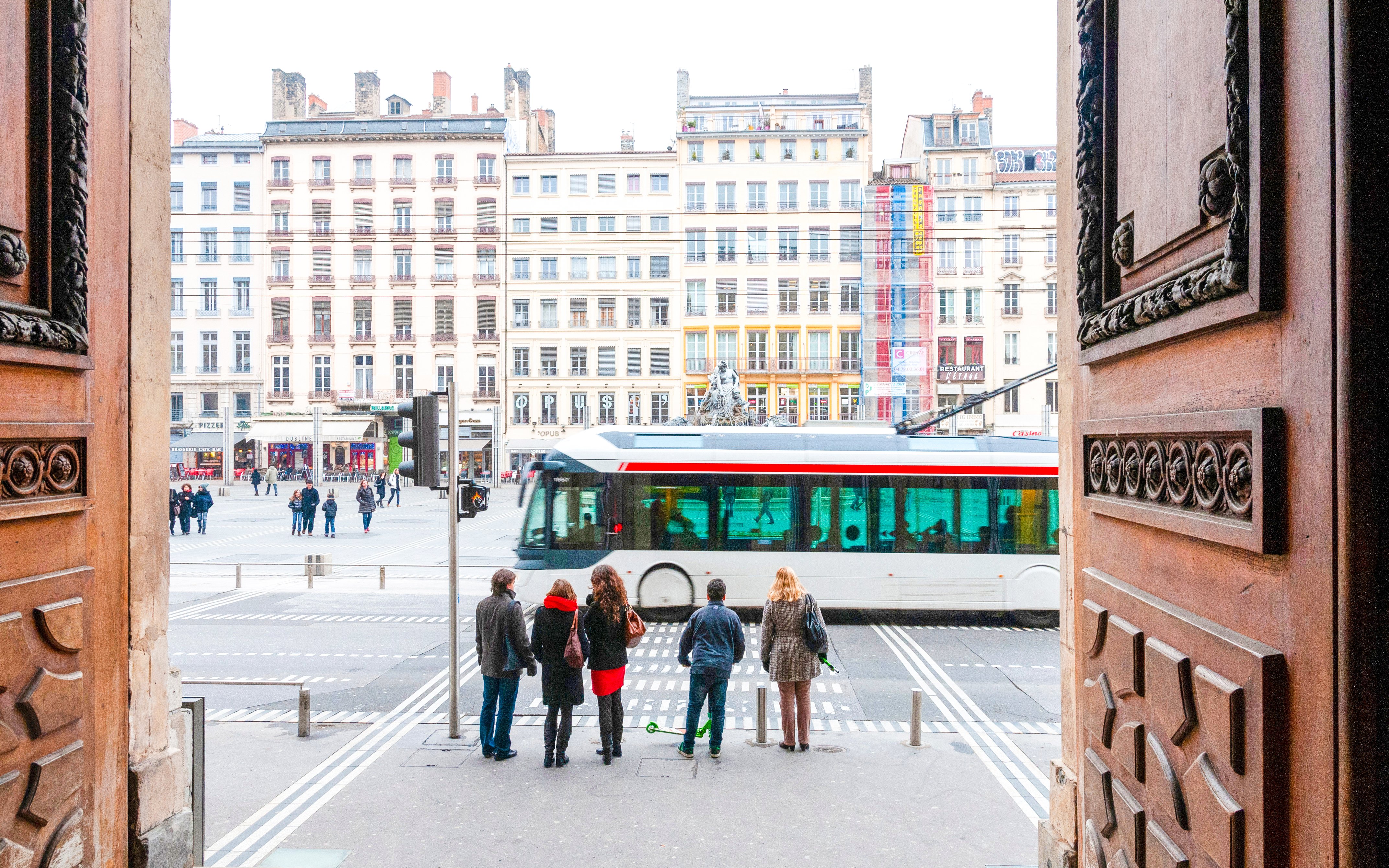 Visitors exiting Museum of Fine Arts Lyon view city square and tram.
