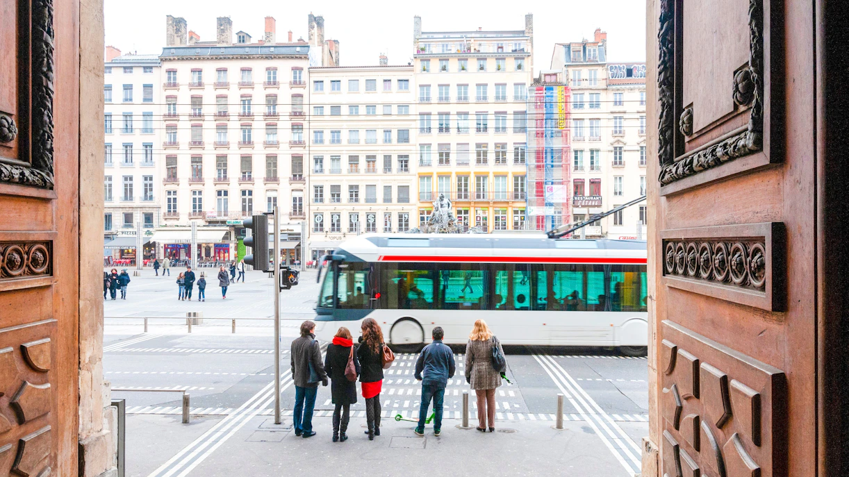 Visitors exiting Museum of Fine Arts Lyon view city square and tram.