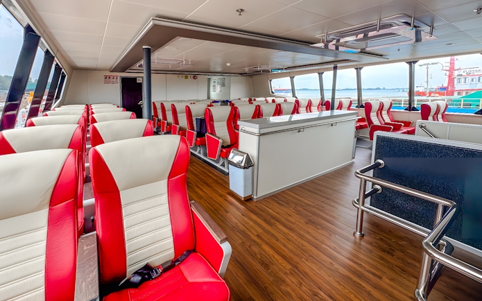 Ferry interior with red and white seats on the Singapore to Batam route.