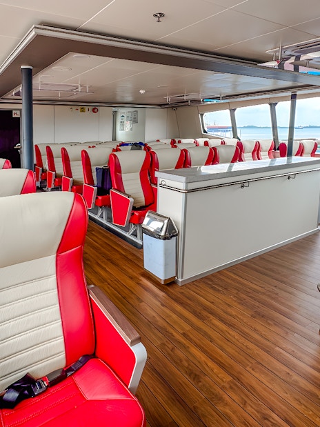 Ferry interior with red and white seats on the Singapore to Batam route.