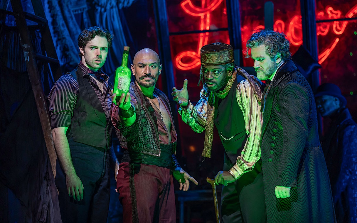 Actors performing a scene in Moulin Rouge! The Musical with a glowing green bottle.