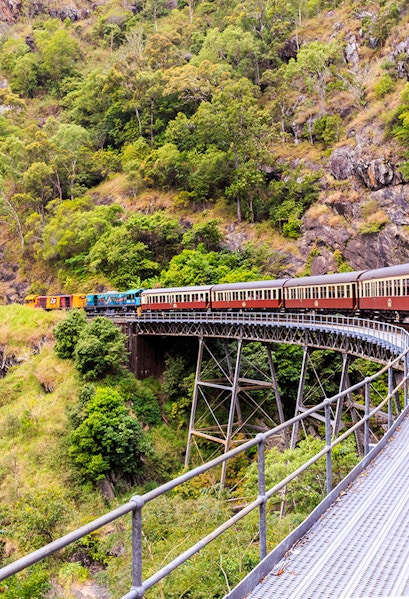 Kuranda Scenic Railway crossing a bridge in lush Cairns rainforest.