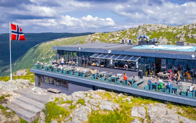 Skyskraperen Restaurant terrace with diners, Ulriken mountain view, Norway.