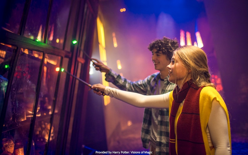 Visitors using wands at Harry Potter: Visions of Magic exhibit.