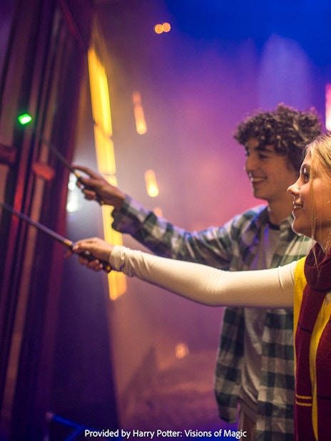 Visitors using wands at Harry Potter: Visions of Magic exhibit.