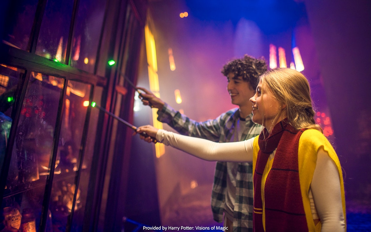 Visitors using wands at Harry Potter: Visions of Magic exhibit.