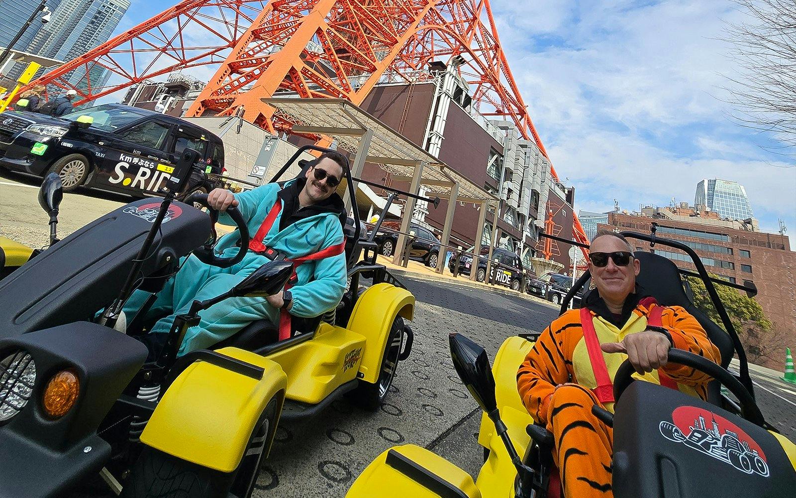 Go-kart riders in costumes near Tokyo Tower on Uptown Go Kart Tour.